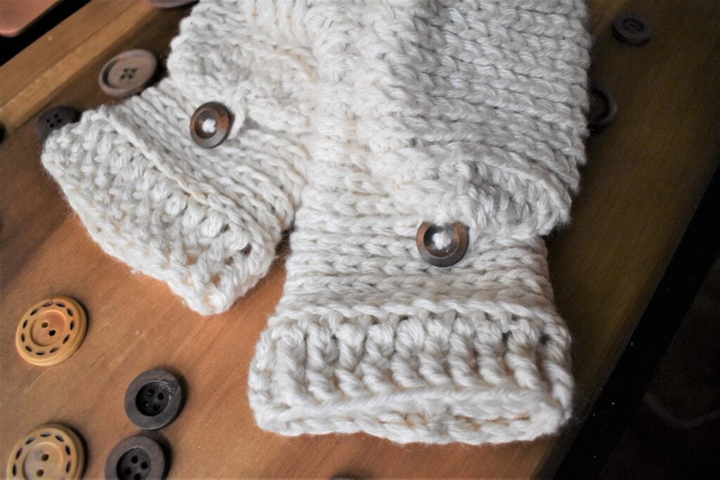 Tabby Star Crochet mittens assembly sitting on wood board.