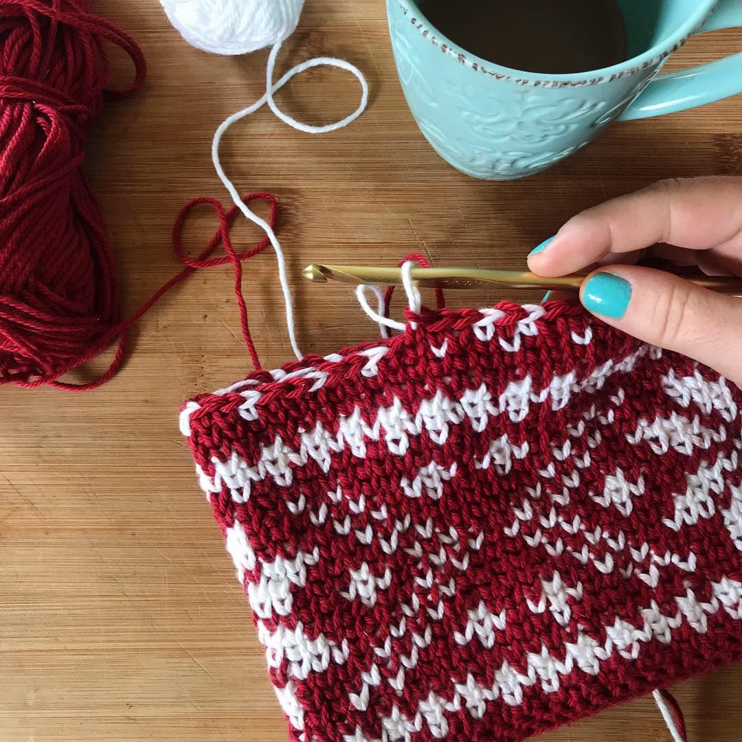 blue cup with hand and crochet hook fair isle crochet beanie