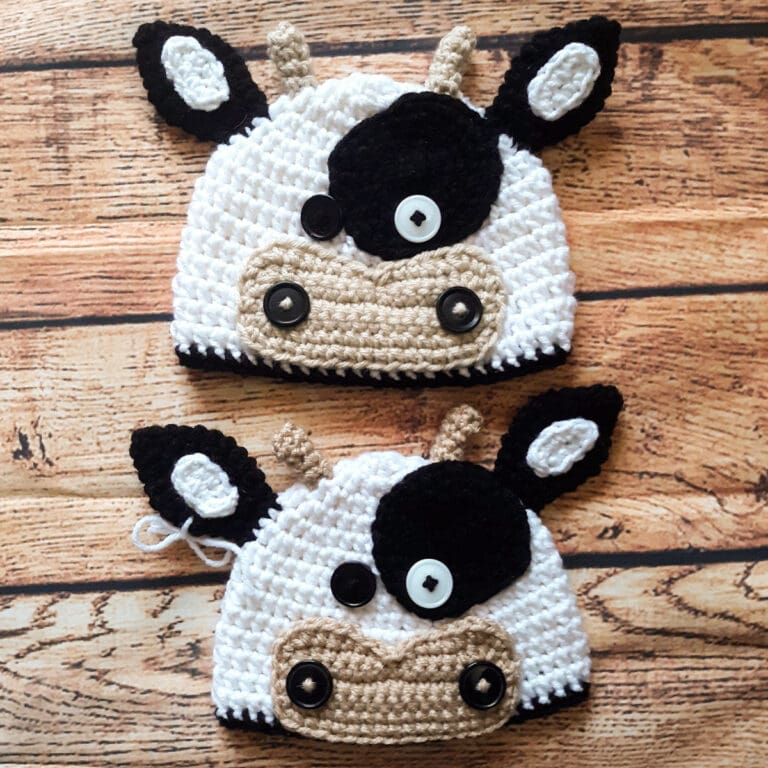 black and white cow crochet beanie on wood table