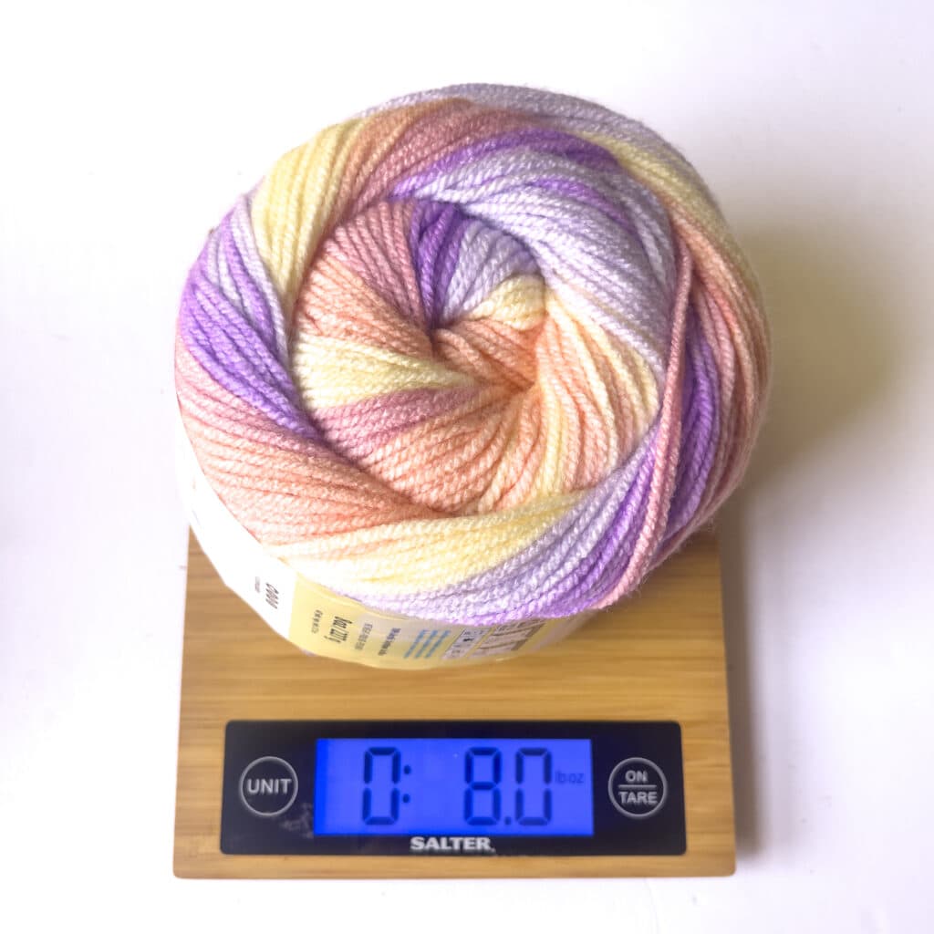 Cinnamon Swirl yarn on a scale showing the full weight of unused yarn