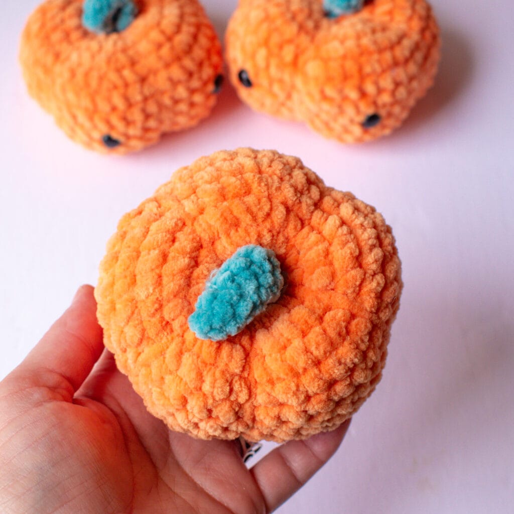 close up of cute amigurumi crochet pumpkin in plushie yarn parfait chunky in tangerine
